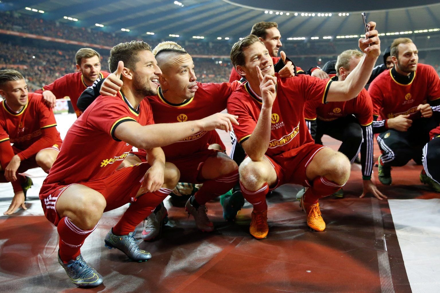 Dries Mertens (l.), Radja Nainggolan (m.) und Jan Vertonghen feiern die Qualifikation für Europameisterschaft in Frankreich.