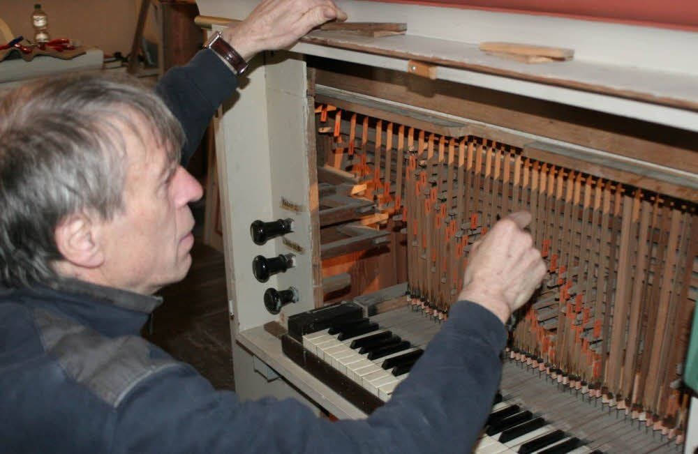 Orgelbauer Rainer Wolter beim Überprüfen der mechanischen Traktur (Holzleisten-Züge zwischen Tasten und Ventilen).