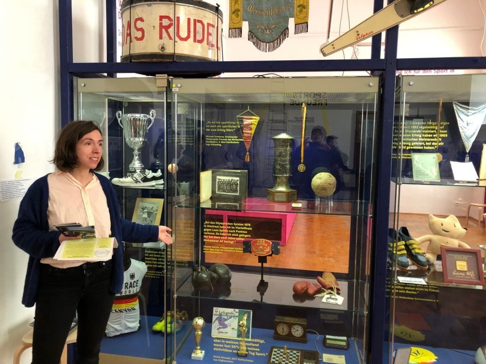 Projektleiterin Andrea Wieloch zeigt die Vitrine mit Exponaten der Weißenfelser Sportgeschichte.
