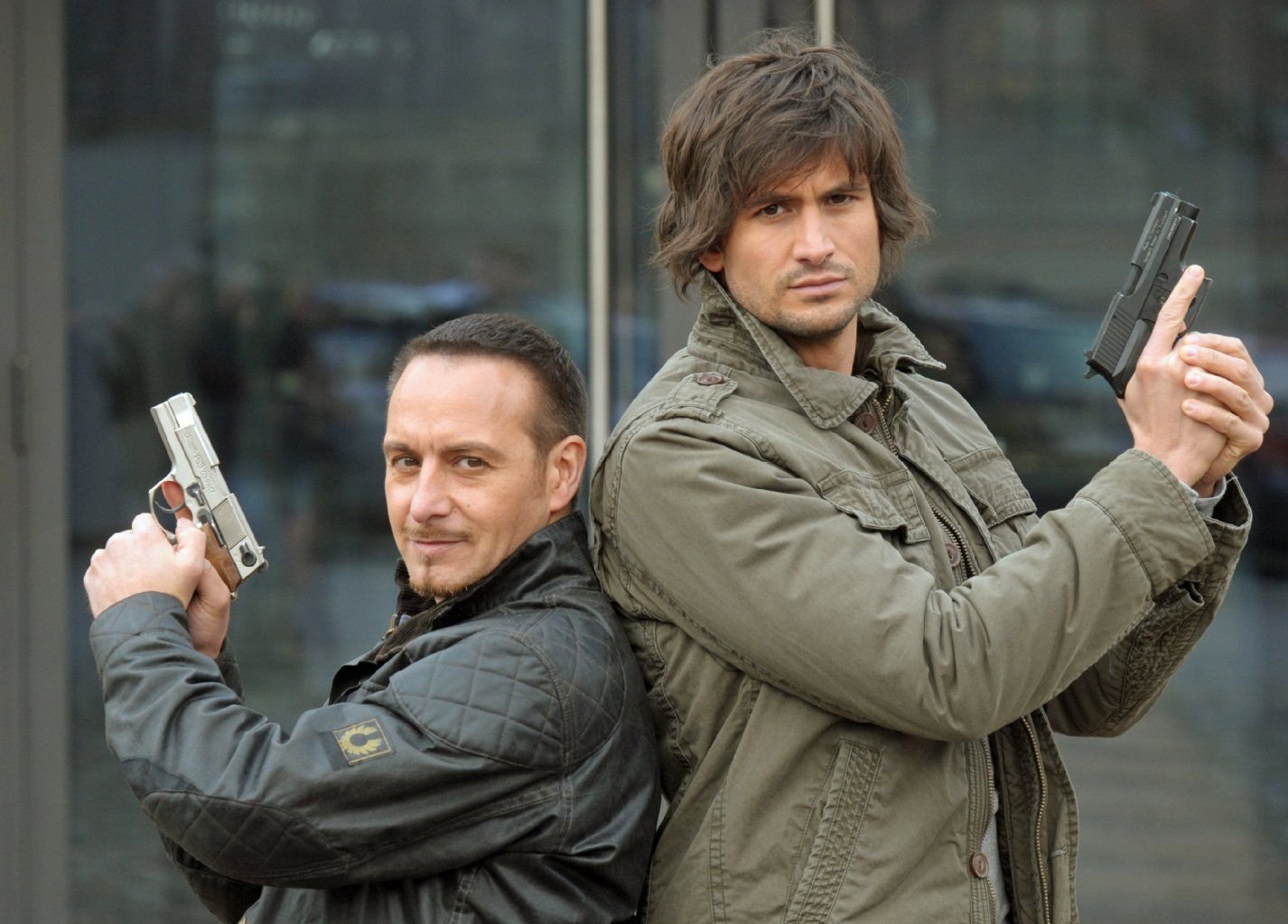 Tom Beck (r, als Ben Jäger) und Erdogan Atalay (als Semir Gerkan) posieren mit Pistolen bei Dreharbeiten der RTL-Ationserie "Alarm für Cobra 11 - Die Autobahnpolizei "