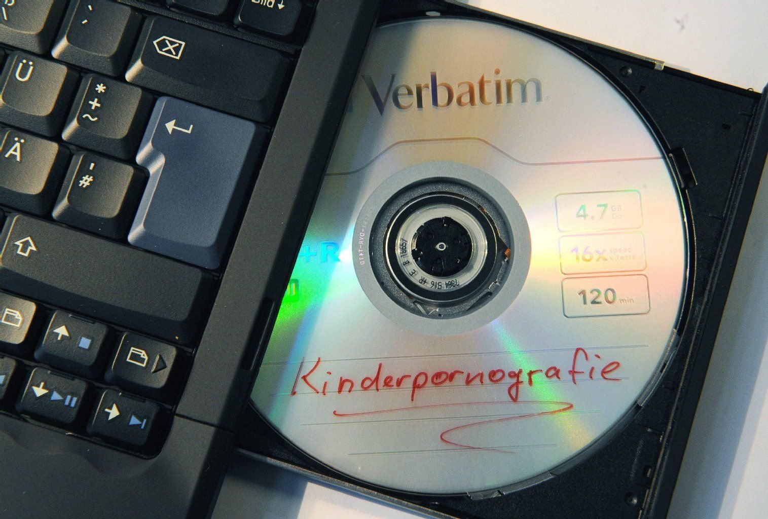 Eine mit "Kinderpornografie" beschriftete CD liegt im Laufwerk eines Rechners.