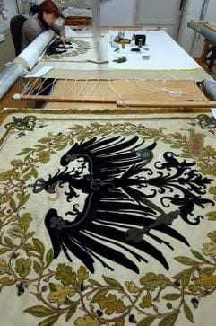 Die Stickerin Ilona Fitzner arbeitet in der Textil- und Gobelinmanufaktur Halle GmbH an einer Kopie zu einer über 200 Jahre alten Fahne der Salzwirkerbrüderschaft Halle/Saale. (Foto: dpa)