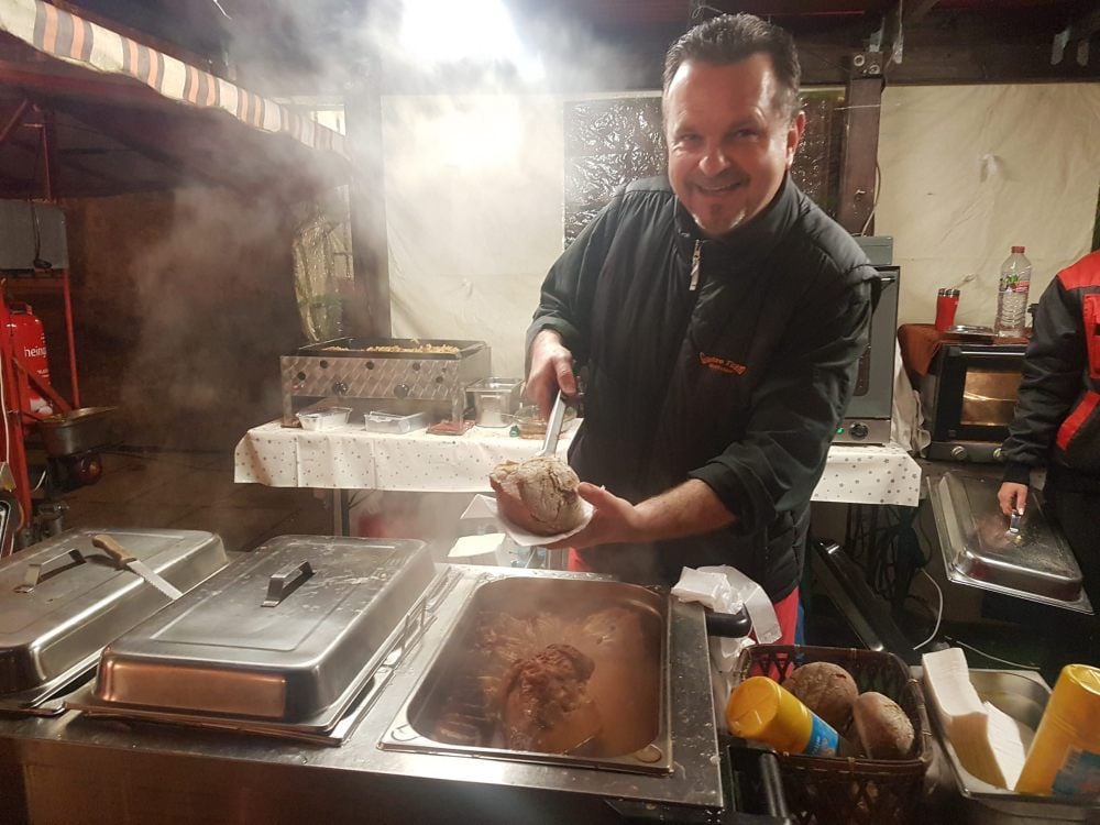 Henryk Huffziger serviert heißes Spanferkel im Kartoffelbrötchen. Nach den Bratwürstchen ist es das zweitliebste Gericht der Kunden.