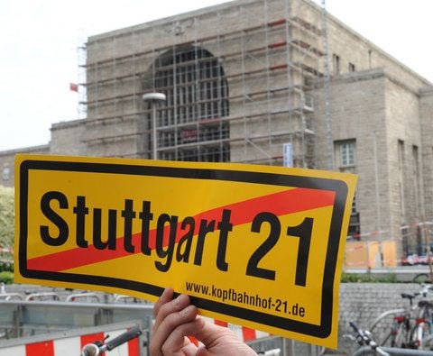Ein S21-Gegner hält 2011 ein Protestschild vor den Stuttgarter Hauptbahnhof.