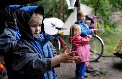 Kinder der Waldkindergruppe «Waldmäuse» waschen sich in der Dölauer Heide in Halle auf einer Wiese die Hände. Insgesamt 20 Kinder werden in der halleschen Waldkindergruppe betreut. (FOTO: DDP)