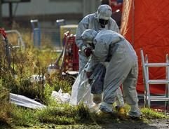 Feuerwehrleute mit Spezialanzügen packen am Dienstag (08.11.2005) in Rhadereistedt bei Zeven (Landkreis Rotenburg) von Kollegen benutzte Ausrüstung ein. (Foto: dpa)