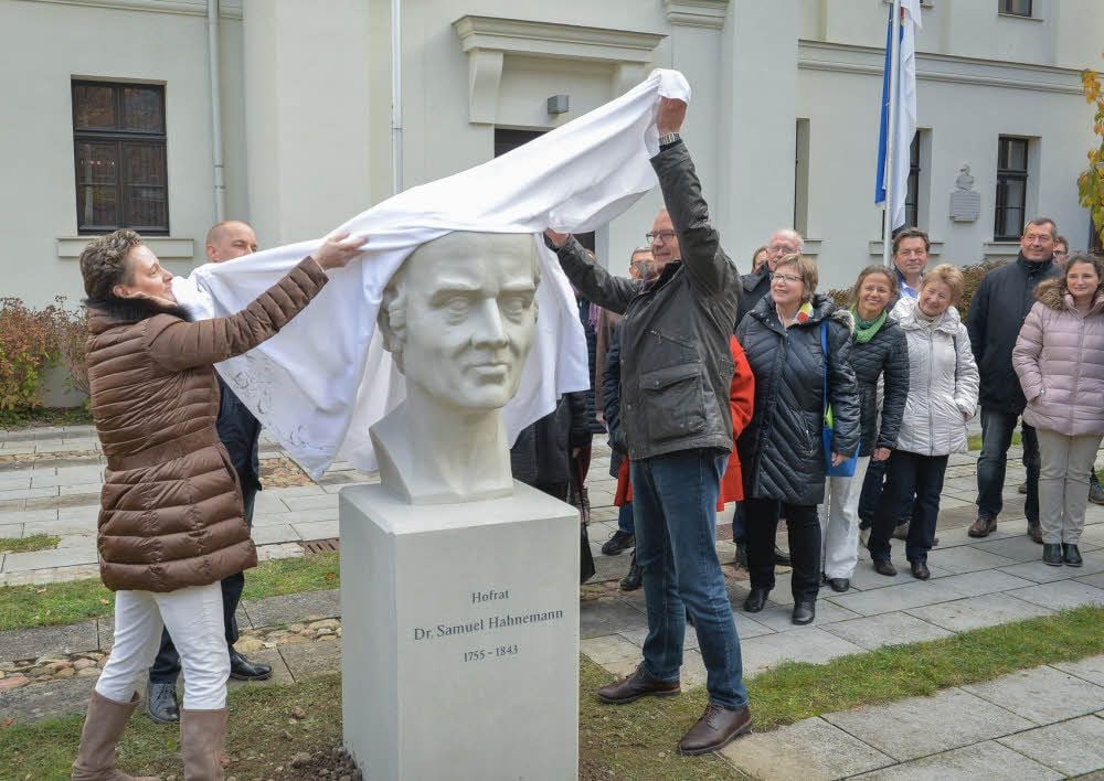 Cornelia Bajic, Chefin des Deutschen Zentralvereins homöopathischer Ärzte, und Köthens OB Bernd Hauschild enthüllen die Hahnemannbüste vor der Europäischen Bibliothek für Homöopathie