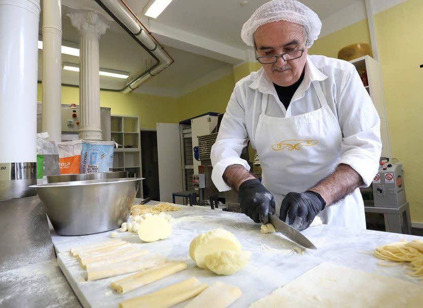 Pastameister Attilio Sabatino schneidet in der gläsernen Manufaktur den Teig für die verschiedenen Pastasorten.
