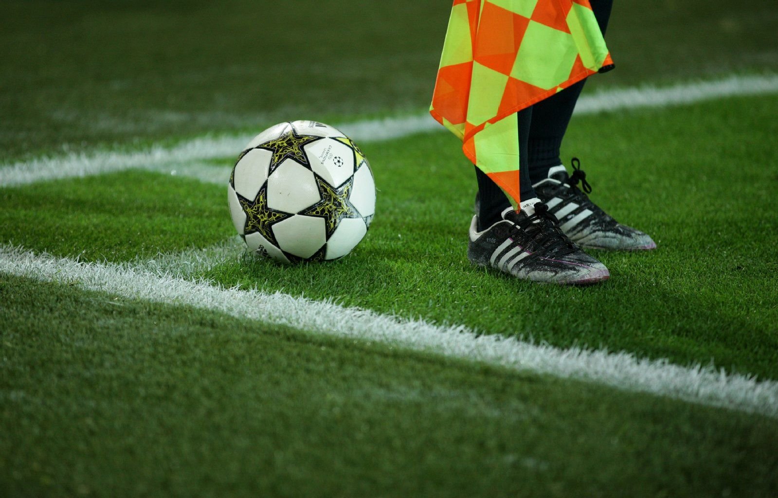 Ein Schiedsrichter steht an der Eckfahne neben einem Ball.