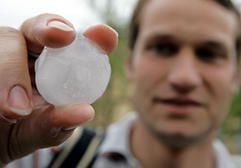 Ein Passant zeigt nach dem schweren Unwetter am Freitag (16. Juni) in Leipzig ein großes Hagelkorn. (Foto: dpa)