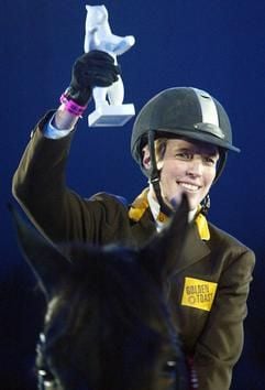 Den Siegerpreis des Großen Preises von Deutschland, einen Berliner Bären aus Porzellan, hält die Springreiterin Meredith Michaels-Beerbaum, gebürtige US-Amerikanerin, am Sonntag (17.11.2002) in Berlin in den Händen. Auf "Shutterfly" gewann Michaels-Beerbaum das mit 77.000 Euro dotierte Weltcup-Reitturnier in der Hauptstadt. (dpa)