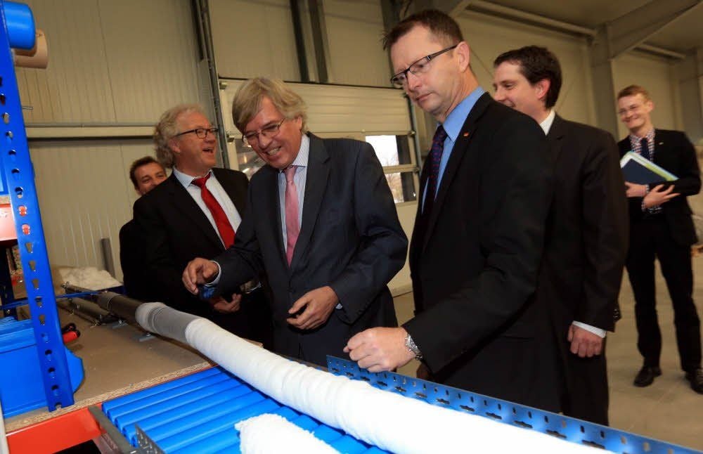 Hartmut Möllring und Dieter Stier (Bildmitte v. l.) an einem Arbeitsplatz bei Deurex, wo Pure in Schlauchform gebracht wird.
