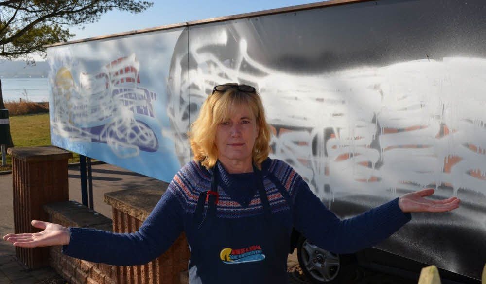 Elvira Krüger vor der besprühten Werbung an ihrem Kiosk am See.