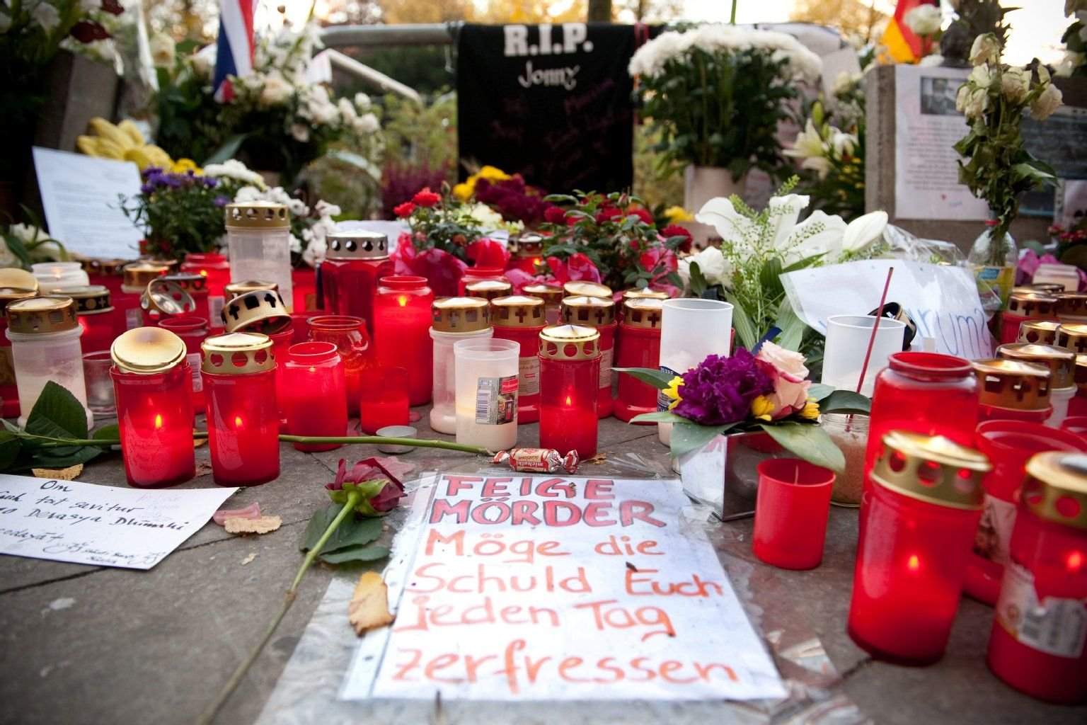 «Feiger Mörder Möge euch die Schuld jeden Tag zerfressen» steht am 20.10.2012 in Berlin vor der Rathaus-Passage am Alexanderplatz vor zahlreiche Kerzen und Blumen, die an dem Ort eines Gewaltverbrechens niedergelegt sind.