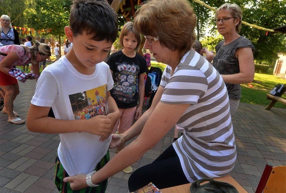 Calvin bekommt das Erinnerungs-T-Shirt von Lehrerin Angela Thierberg übergestreift.