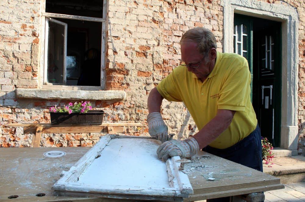 Mühlenbesitzer Wolfgang Sittel arbeitet die alten Fenster wieder auf.