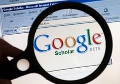 Unter einer Lupe ist am Mittwoch (24.11.2004) auf einem Computermonitor in Schwerin der Schriftzug der neuen Internet-Suchmaschine «Google Scholar» zu sehen (Illustration zum Thema Suchmaschine, Google Scholar, Internet). Der seit einer Woche frei geschaltete Dienst Google Scholar soll Wissenschaftlern und Studenten bei der Recherche zu Fachartikeln helfen. Da der Dienst noch in der Testphase ist, beschränkt sich die Auswertung größtenteils auf englischsprachige Quellen. Wer unter www.scholar.google.com den Namen Martin Luther eintippt, wird verblüfft sein. Nicht etwa der Wittenberger Reformator verbirgt sich hinter den ersten Treffern, sondern eine wissenschaftliche Abhandlung über Umwelteinflüsse auf die Tierwelt. (Foto: dpa)
