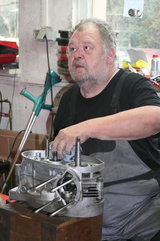 Peter Bannert an seinem behindertengerechten Arbeitsplatz in der Motorrad-Werkstatt von Rüdiger Golm in Annaburg: Hier baut der Prettiner gerade den Zweitakt-Motor einer TS 250 (DDR-Marke MZ) zusammen.