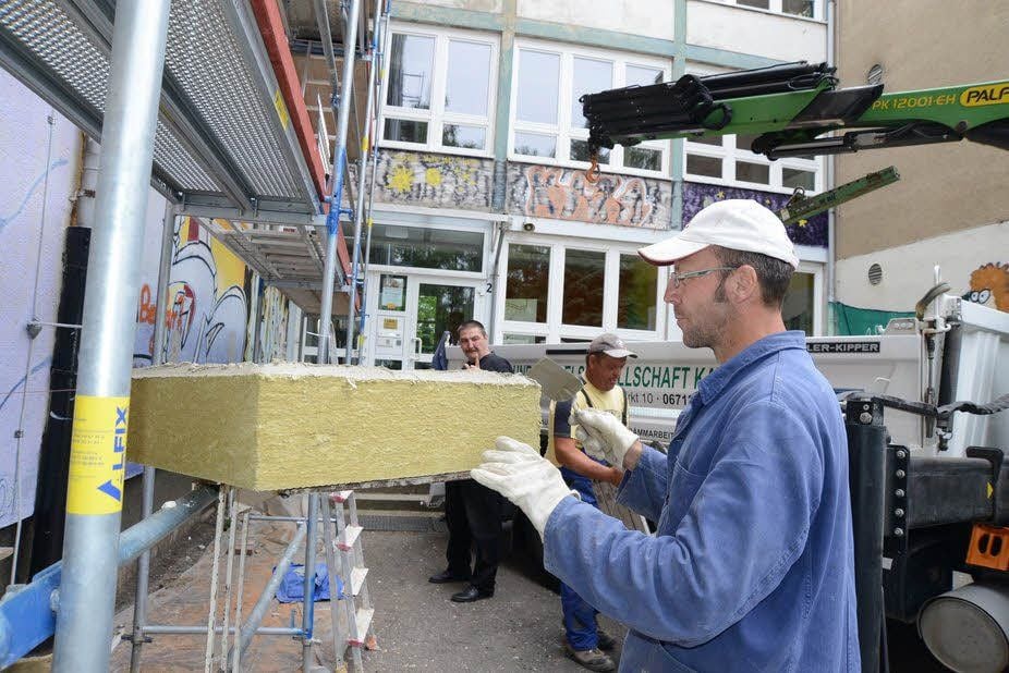 Eine neue Wärmedämmung erhält die Schule Am Schwanenteich in Zeitz. 16 Zentimeter dick ist das Dämmmaterial. Lutz Ulle von der Firma Hochbau- und Handelsgesellschaft Kayna mbH streicht den Kleber auf Platte.