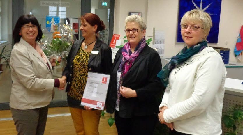 Bärbel Schön (li.) übergibt das Zertifikat an Gabriele Isermann im Beisein von Bürgermeisterin Doris Berlin (Mitte) und Elke Witt.