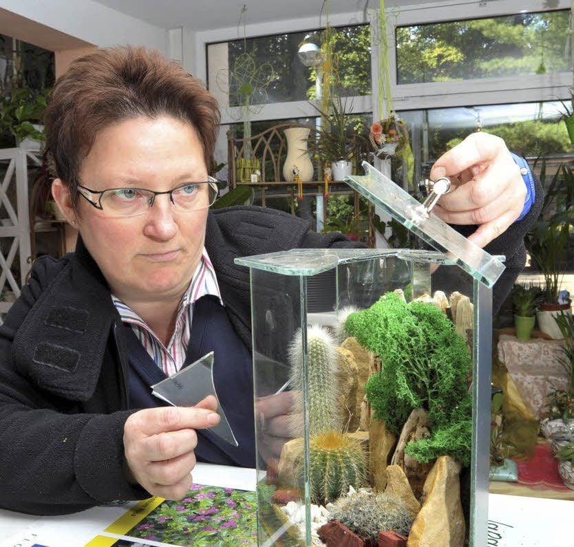 Anke Fechner, Mitarbeiterin im „Blumenparadies“, zeigt eine der Vasen, die beim jüngsten Einbruch kaputt gegangen sind. Die Täter stiegen durch ein Fenster von der Friedhof-Seite (hinten) ein.