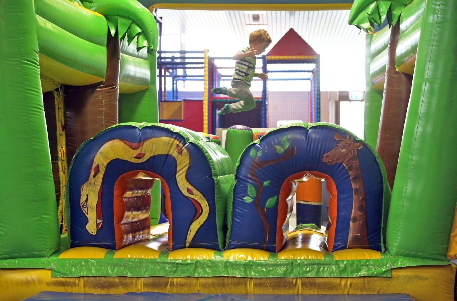 Ein kleiner Junge springt in einer Hüpfburg im Kinderspielparadies Arche Noah in Halle/Saale.