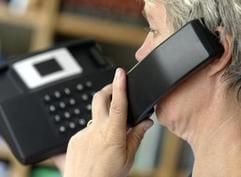 Ein Frau führt ein Gespräch über ein Festnetz-Telefon. (Foto: dpa)