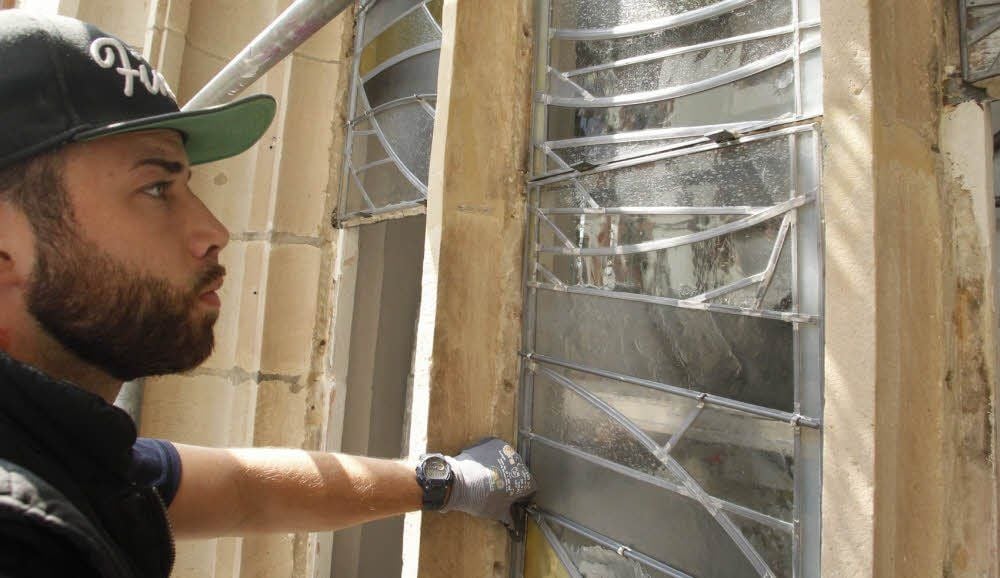 David Sczesny von der Glasmalerei Peters aus Paderborn baut an der Petrikirche ein neues Fenster-Feld ein.