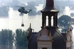 Hubschrauber mit Sandsäcken über der Hochwasser