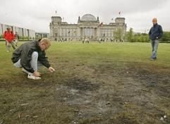 Ein Mann sucht am Samstag (23.07.2005) in Berlin vor dem Reichstag an der Absturzstelle des Leichtflugzeuges nach Trümmerresten. (Foto: dpa)