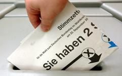 Ein Wähler steckt einen Stimmzettel zur Bundestagswahl in eine Wahlurne. (Foto: dpa)