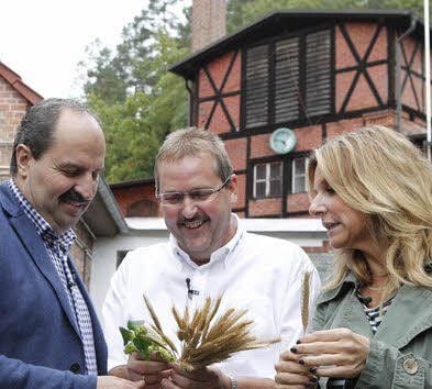 Norbert Gehring zeigt Johann Lafer und Kim Fisher die Gerste und den Hopfen, die er nimmt.