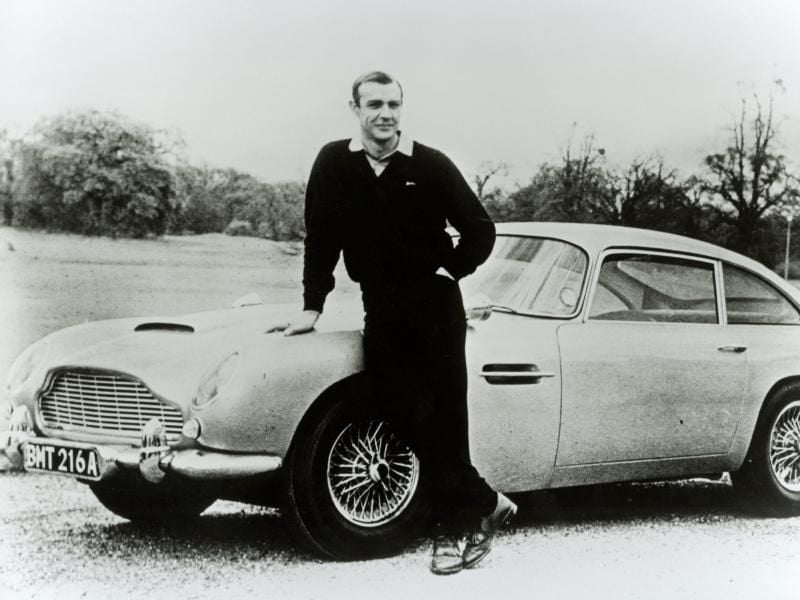 Ein Mann, ein Auto: James Bond alias Sean Connery posiert vor einem Aston Martin DB5.