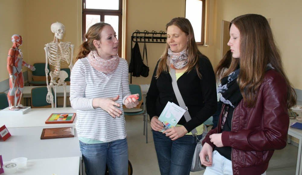 Dozentin Lisa Haedicke (links) berät Mutter Katrin Gutschalk mit ihrer Tochter Lisa aus Halle bei der Berufswahl.