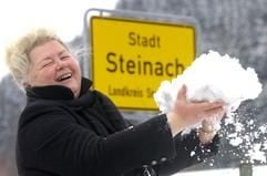 Maria Greiner, Bürgermeisterin von Steinach (Kreis Sonneberg) hat am Mittwoch (8. März 2006) am Ortseingangsschild der südthüringischen Stadt Schnee in den Händen.