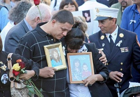 Angehörige von Opfern der Anschläge auf das World Trade Center am 11. September 2001 stehen während der Gedenkfeier mit Fotos am Ground Zero eng aneinander. (FOTO: DPA)
