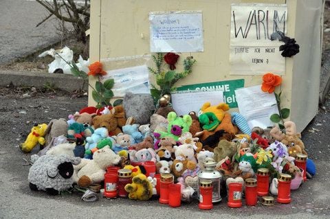 Kerzen und Plüschtiere liegen in Schwarzenberg vor einem Altkleidercontainer, in dem im Januar 2011 ein totes Baby gefunden worden war. (FOTO: DPA)