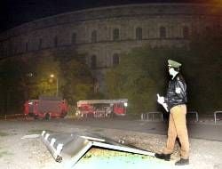 Ein Polizeibeamter steht am Montag vor einer Stahltür, die über 100 Meter aus der Kongreßhalle in Nürnberg geschleudert wurde. In der Nacht zum Montag erschütterte eine Explosion die Kongreßhalle auf dem ehemaligen Reichsparteitagsgelände in Nürnberg. Ein Feuerwehrmann wurde beim anschließenden Brand leicht verletzt. Die Ursache für die Explosion ist nach Polizeiangaben derzeit noch unklar.