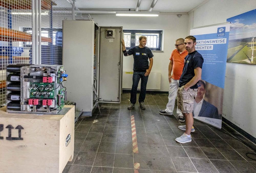 Uwe Rühle (li.) erklärt im neuen Zentrallager in der Triftstraße die Instandsetzung von Wechselrichtern für Windenergie-Anlagen.