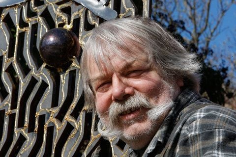 Der Künstler Joachim Matz steht in Tremmen (Brandenburg) vor einem Kunstwerk mit einer Kugel. (FOTO: DPA)