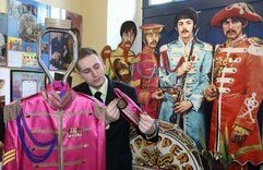 Die Nachfertigung der SGT. Pepper-Uniform, die Ringo Starr von den Beatles trug, richtet der Museumsmitarbeiter Martin Schmidt im Beatlesmuseum in Halle/Saale. (Foto: dpa)