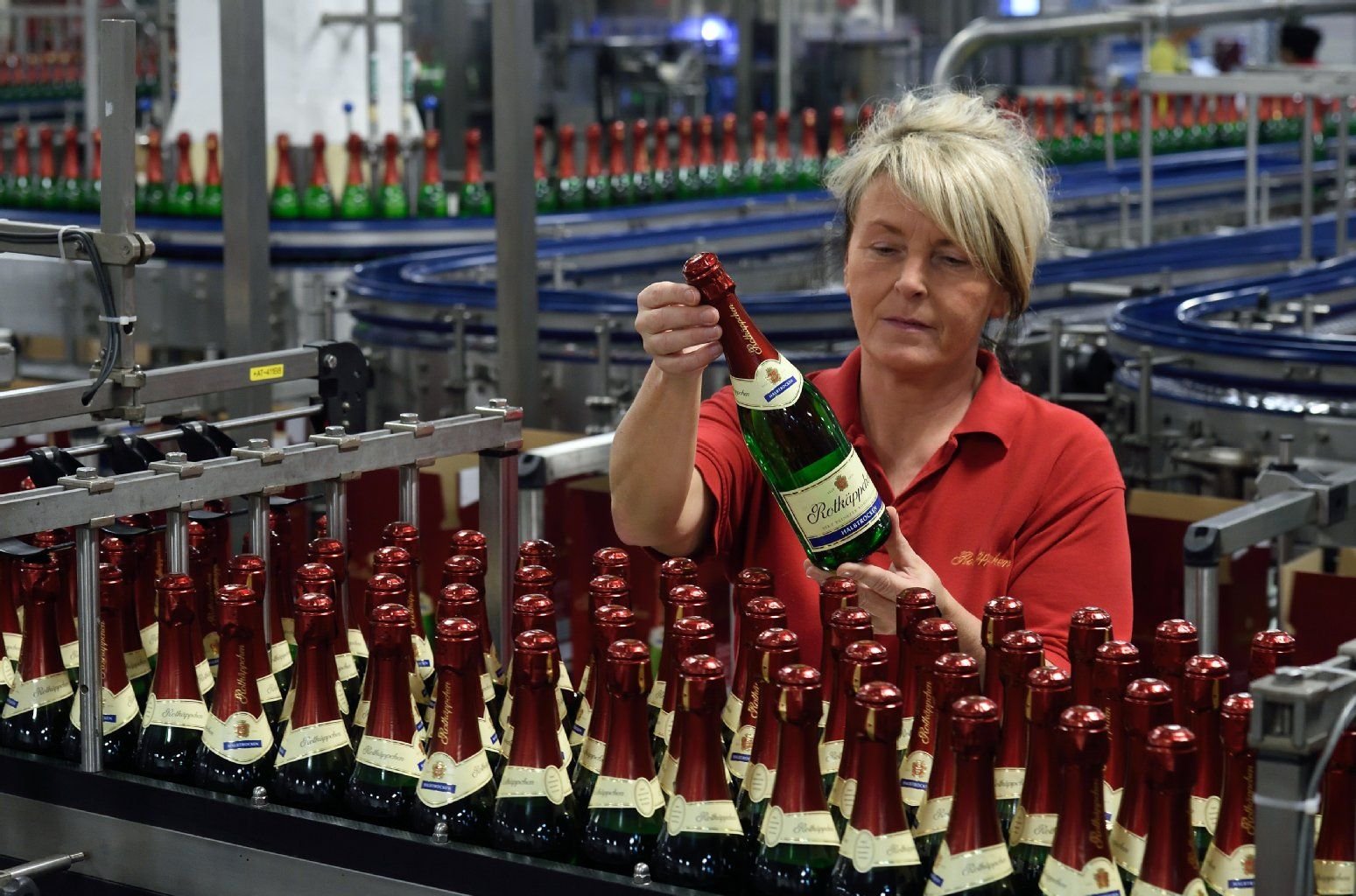 In der Rotkäppchen-Mumm-Sektkellerei in Freyburg kontrolliert Elke Fieker Sektflaschen an der Verpackungslinie.
