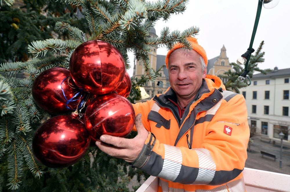 Henry Holzknecht hat am Montag den frisch aufgestellten Weihnachtsbaum auf dem Köthener Marktplatz weihnachtlich aufgehübscht.