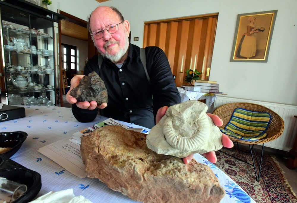 Gerhard Beutler zeigt einen Eisenmeteoriten (links) und einen etwa 180 Millionen Jahre alten Ammoniten.
