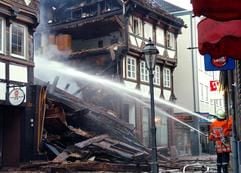 Feuerwehrmänner löschen ausgebrannte und eingestürzte Fachwerkhäuser am Mittwoch (30.03.2005) in Einbeck. Eine Explosion hatte am frühen Morgen in der Altstadt von Einbeck (Kreis Northeim) zwei Häuser zerstört. Bei drei weiteren Gebäuden bestand Einsturzgefahr. Nach ersten Ermittlungen geht die Polizei von Brandstiftung als Ursache für die Explosion und das Feuer aus. Zwei Feuerwehrmänner und ein Polizist wurden schwer verletzt, sagte ein Polizeisprecher. 30 Bewohner wurden rechtzeitig in Sicherheit gebracht. (Foto: dpa)