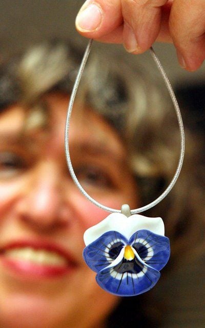 Die Porzellanmacherin Heidi Hütter zeigt in ihrer Werkstatt in Wernigerode, der nach eigenen Angaben kleinsten Porzellanmanufaktur Europas, ein Halsschmuck aus Porzellan. (FOTO: DPA)