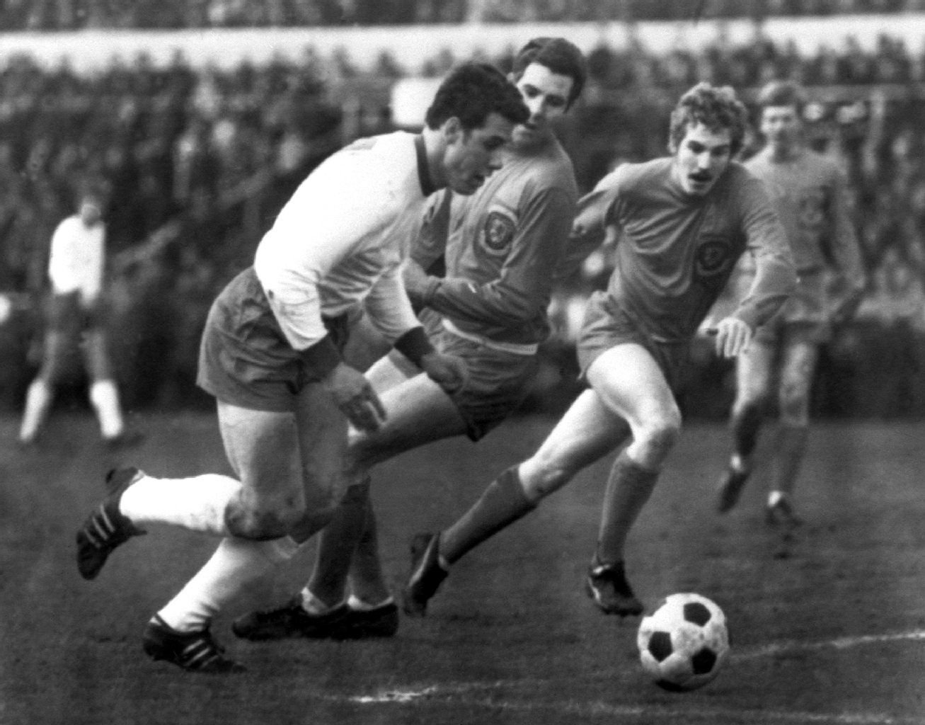 DDR-Stürmer Eberhard Vogel (l) überläuft zwei walisische Gegenspieler.