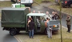 Beteiligte des Prozesses um den Tod eines Bundeswehrsoldaten im Kosovo stehen am Freitag (12.12.2003) im Innenhof des Amtsgerichts von Halle (Saale) um einen VW-Transporter, der zur Rekonstruktion des Tathergangs dienen soll. Ein 27-jähriger Soldat hatte im Kosovo-Einsatz bei einer Dienstfahrt in der Stadt Prizren am 15.12.2002 einen 21-jährigen Sanitätssoldaten getötet. Nach Aussagen des Angeklagten, löste sich der Schuss versehentlich, als er im Fahrzeug die Pistole überprüfen wollte. Bei dem zum Gerichtstermin in Halle vorgestellten Transporter handelt es sich um ein baugleiches Modell, da das Originalfahrzeug weiterhin im Kosovo unterwegs ist. (Foto: dpa)