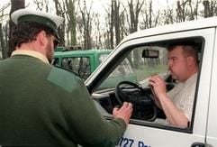 Ein Polizist kontrolliert bei einem Autofahrer den Atemalkoholwert. In Deutschland kann bereits 0,5 Promille im Blut am Steuer den Führerschein kosten. (Foto: dpa)
