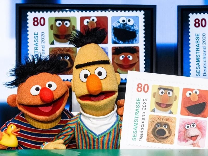 Ernie und Bert präsentieren die Sonderbriefmarke. Foto: Markus Scholz/dpa